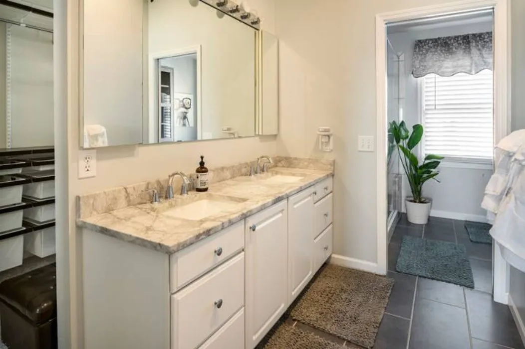 Bathroom with a double vanity and a walk-in shower beyond